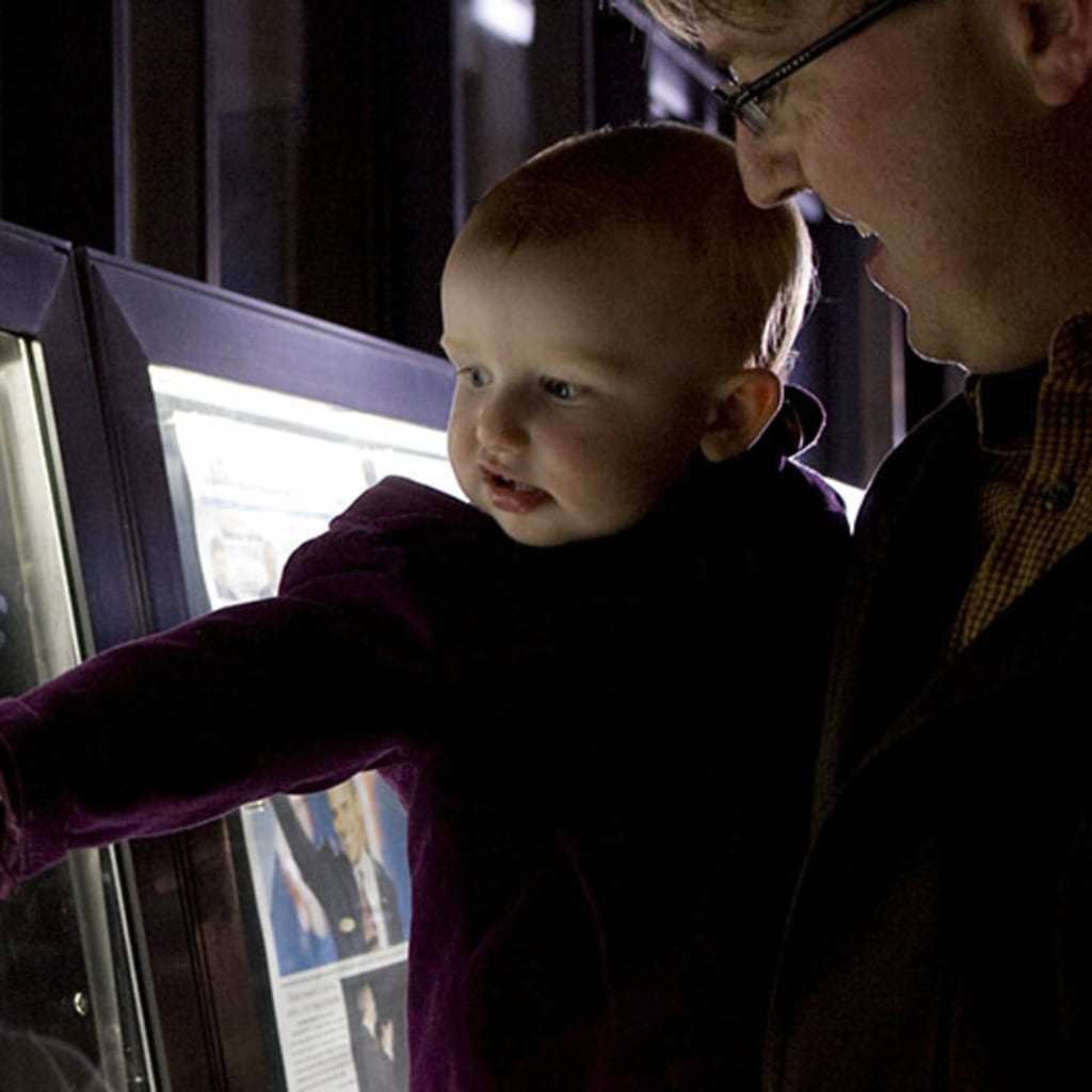 Baby and her father view the front page newspapers after the historic win by Democrat Barack Obama, in the 2008 election