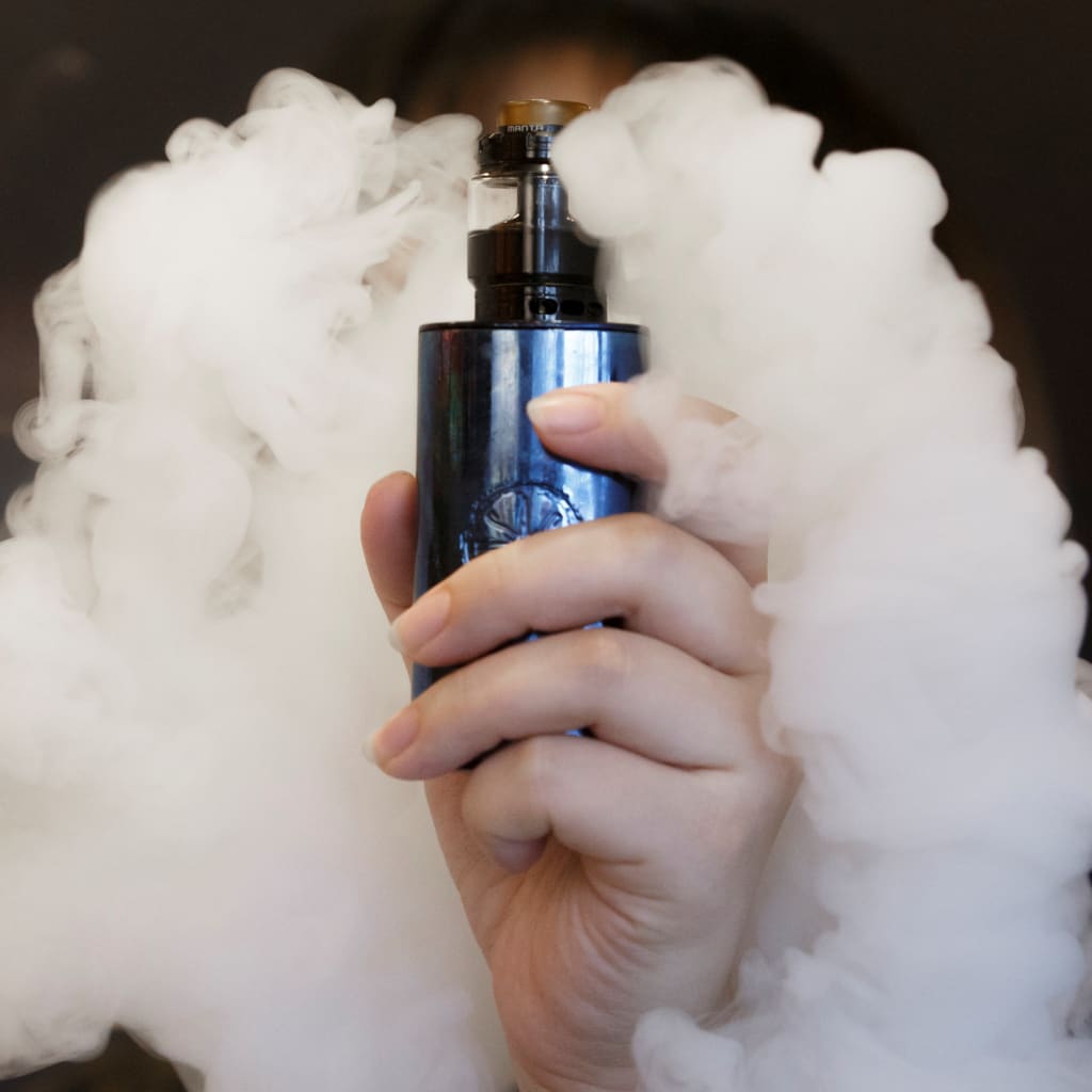 <p>A saleswoman holds an e-cigarette.</p>

