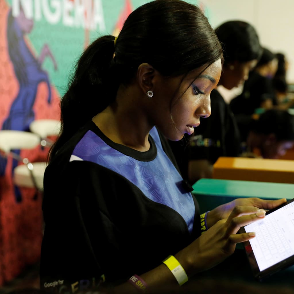 Youths browse the internet inside the venue of the launch of Google free wifi project in Nigeria July 26, 2018.