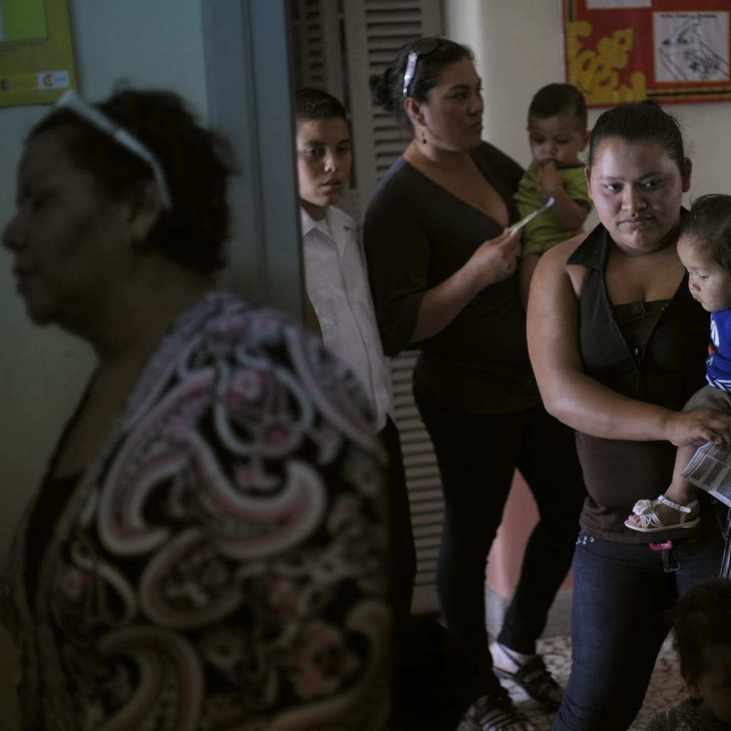 <p>Women and their children wait in line to receive a polio vaccine shot at a health center in Tegucigalpa, Honduras.</p>
