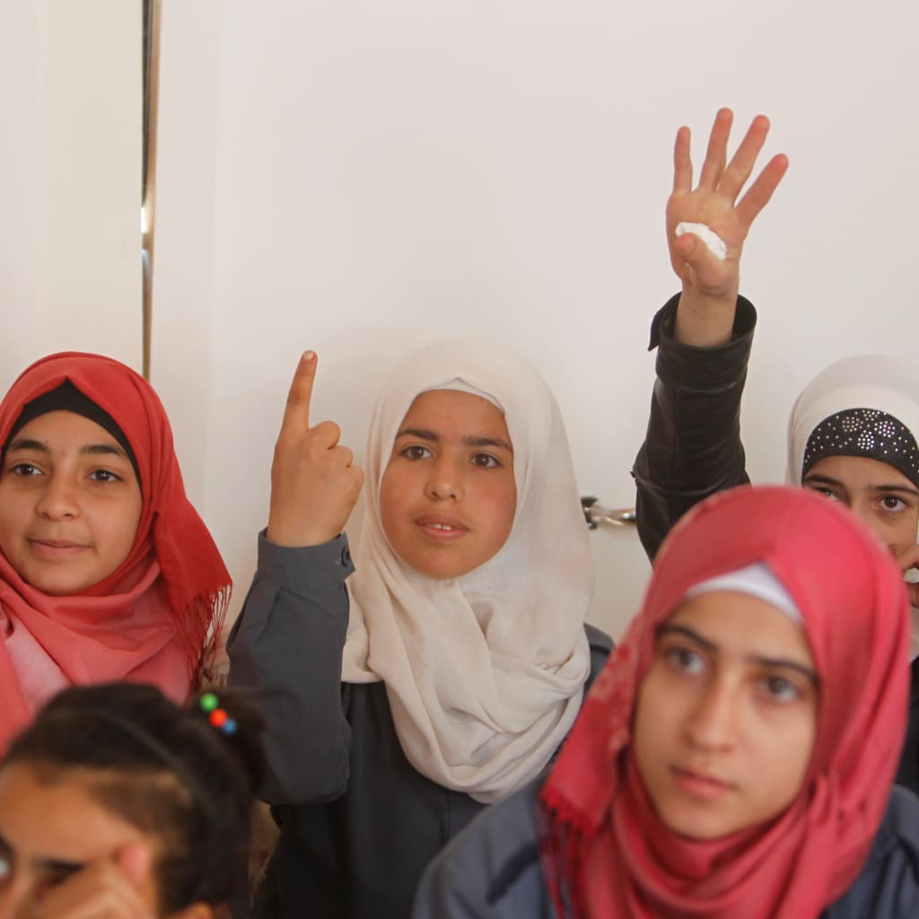 <p>Syrian refugee girls gesture as they sit inside a classroom at a school for Syrian refugee girls in Lebanon, October 19, 2017. </p>
