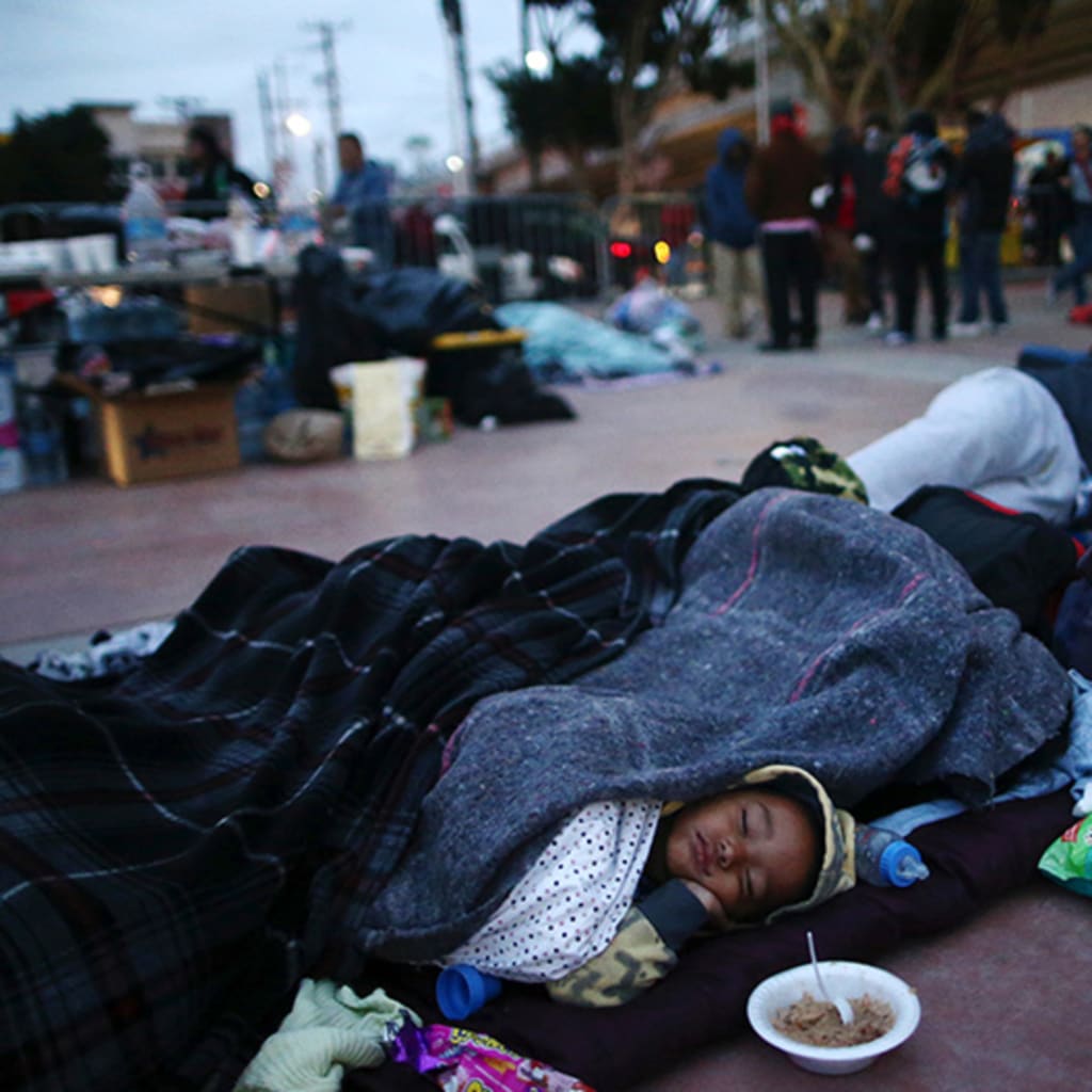 Members of a caravan of migrants from Central America sleep near the San Ysidro checkpoint