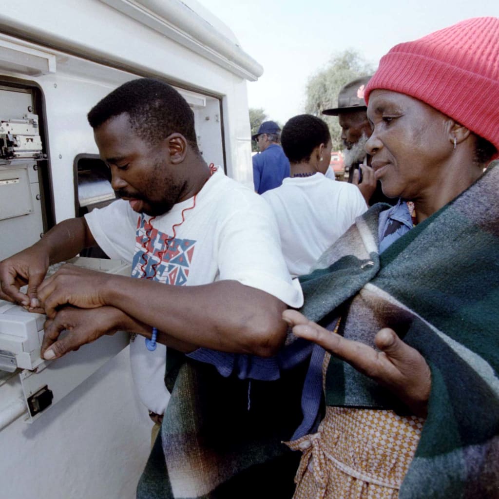 <p> A bank operator takes the fingerprint of a South African woman at a mobile cash dispenser in this township of the remote former homeland of KwaNdebele May 10.</p>
