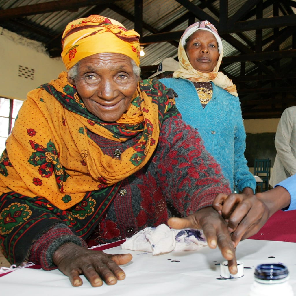 <p>An election official helps a Kenyan woman cast her vote at a polling station in Nyeri district, Kenya November 21, 2005. [</p>
