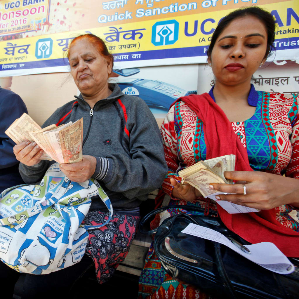 <p>Women count Indian rupee banknotes before depositing them at a bank in Chandigarh, India. November 10, 2016.</p>
