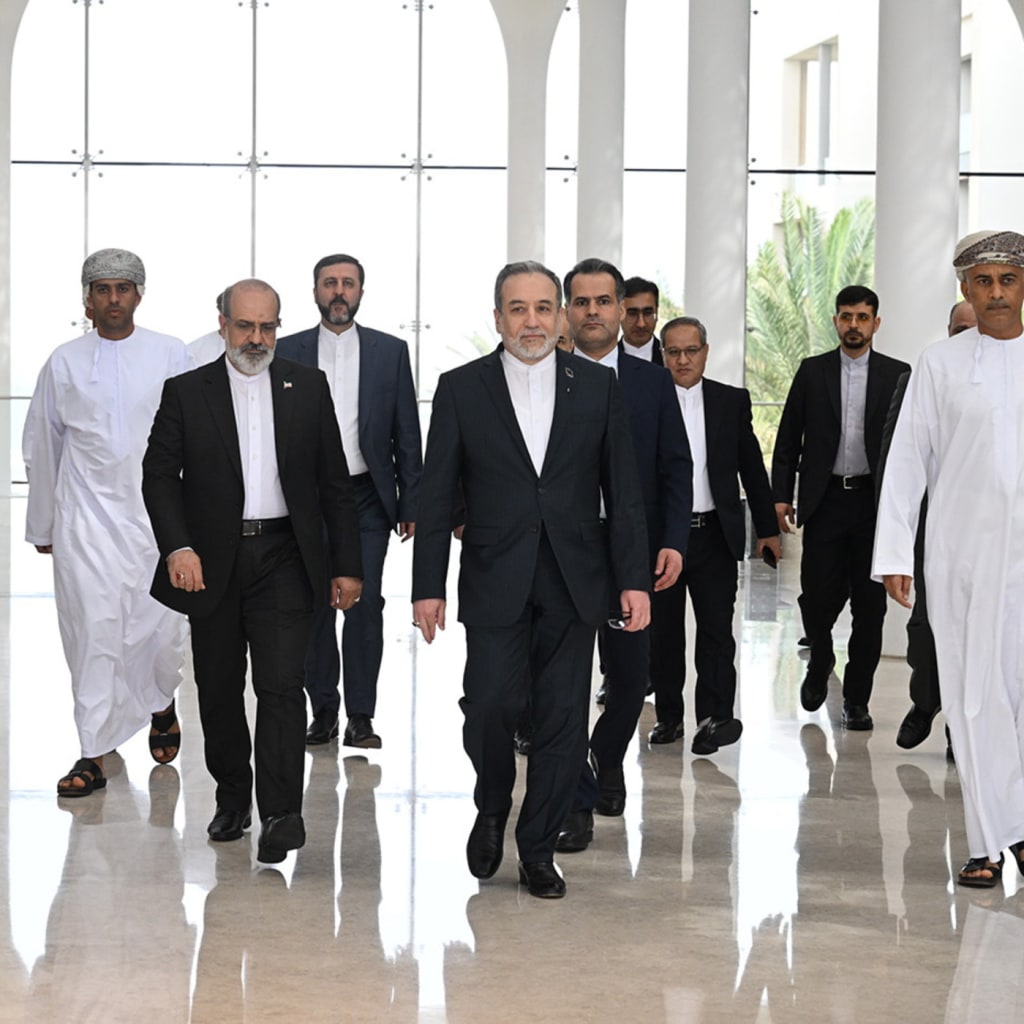Iranian negotiators walk in formal attire down a hallway.