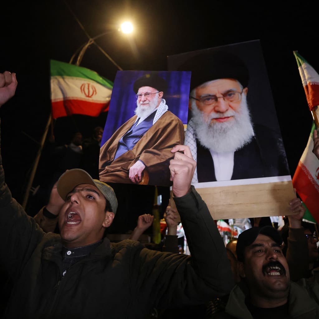 Iraqi Shiites shout slogans as they carry a portrait of Iran's Supreme Leader Ayatollah Ali Khamenei and wave Iran flags during a protest against U.S. and Israeli attacks on Iran at a bridge leading to Green Zone where the U.S. embassy is located.