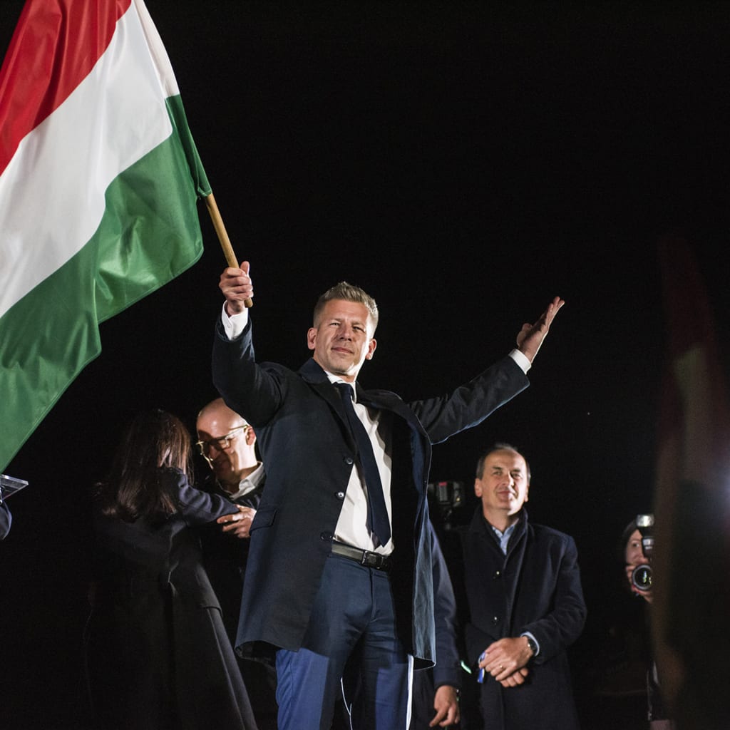 Peter Magyar waves the Hungarian flag after his speech during his party's election night event in Budapest on Sunday, April 12, 2026.
