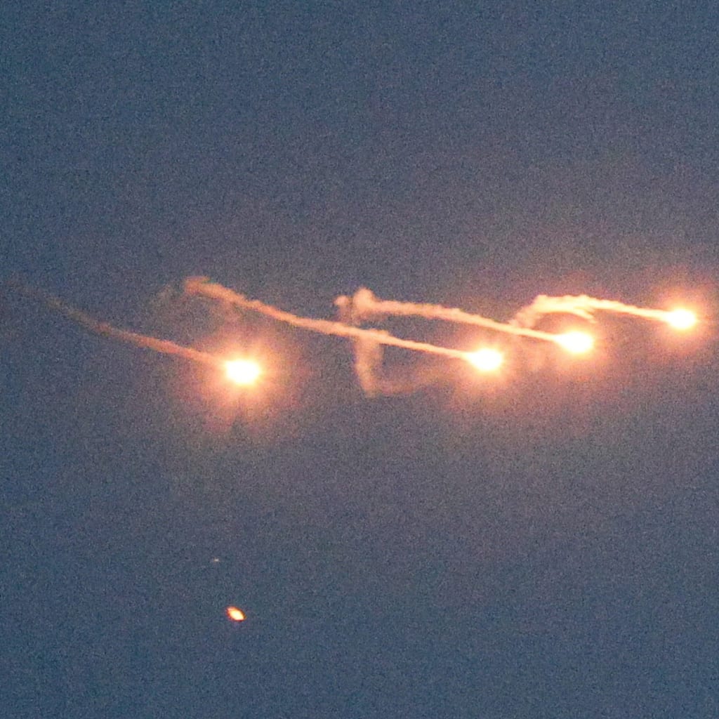 An Israeli helicopter releases flares as it flies over Lebanon, as seen from the Israeli side of the border with Lebanon