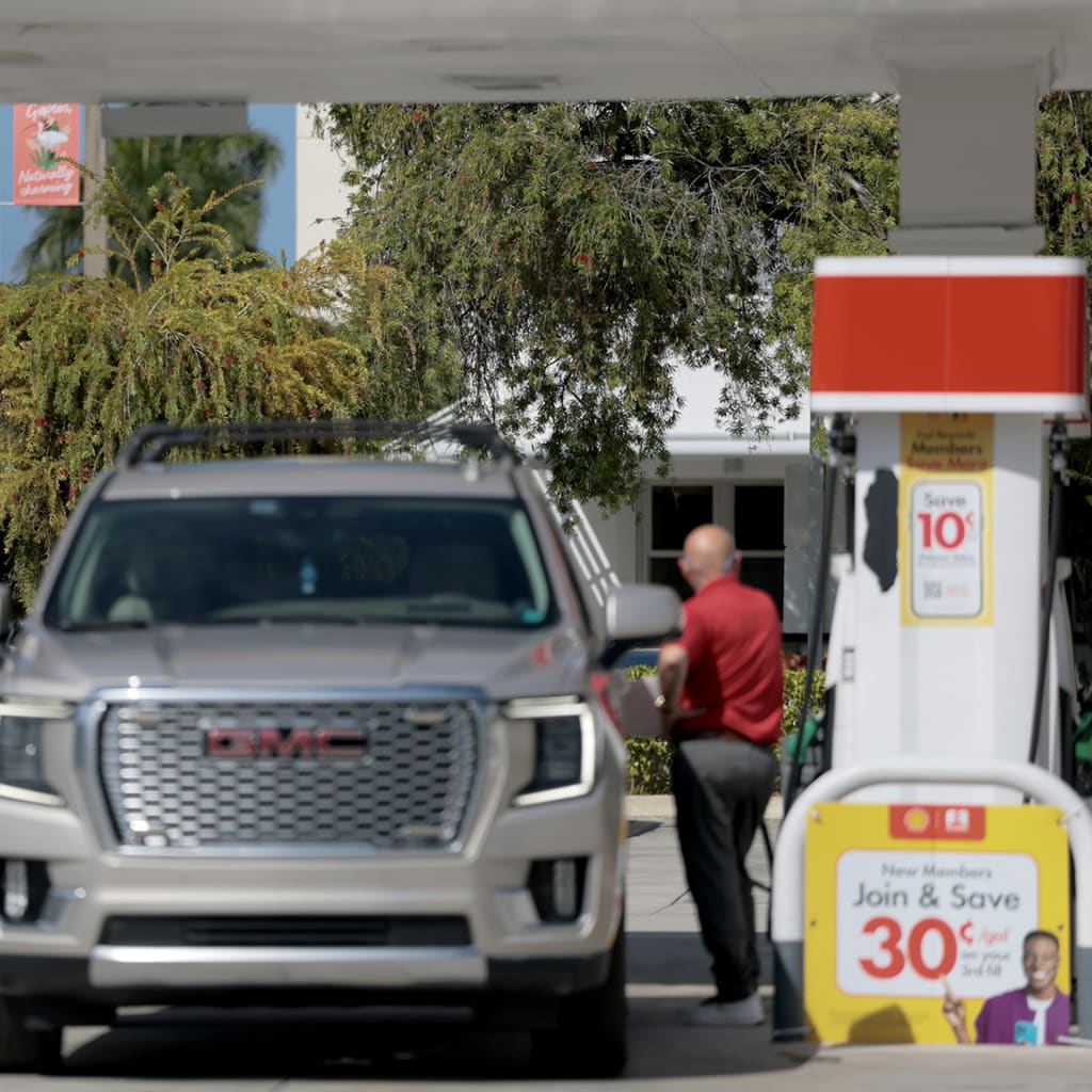 Fuel prices are displayed on a sign as a customer fills their vehicle at a gas station on April 13, 2026 in Miami, Florida.