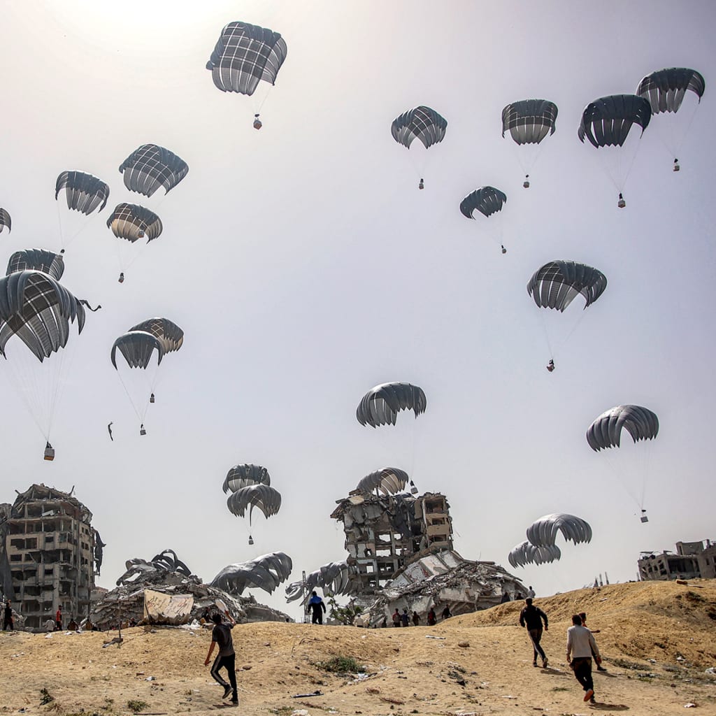 Parachutes fill the landscape with aid during an aid drop in Gaza.