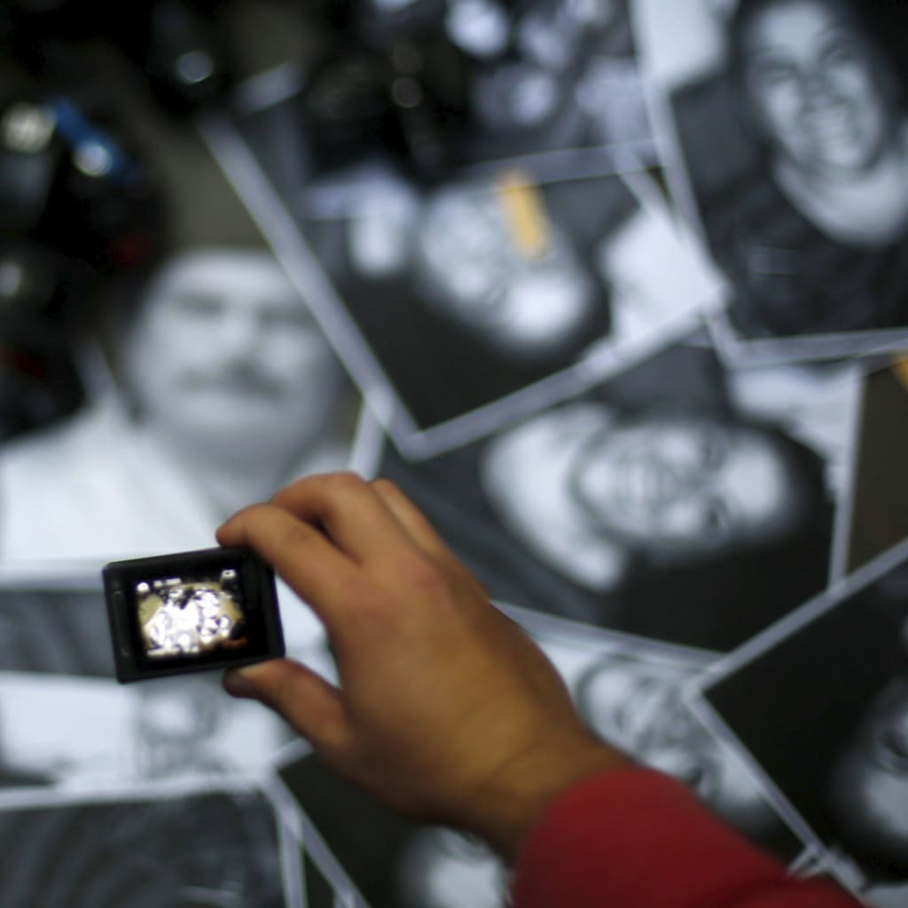 A woman takes photos of images of murdered journalists during a demonstration against murder of the journalist Anabel Flores outside the Government of Veracruz building in Mexico City