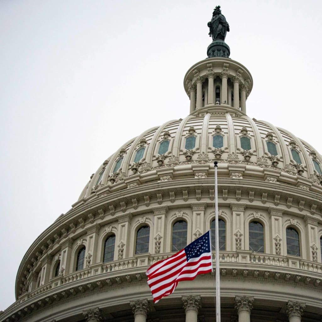 The American flag flies at half staff at the U.S. Capitol Building.