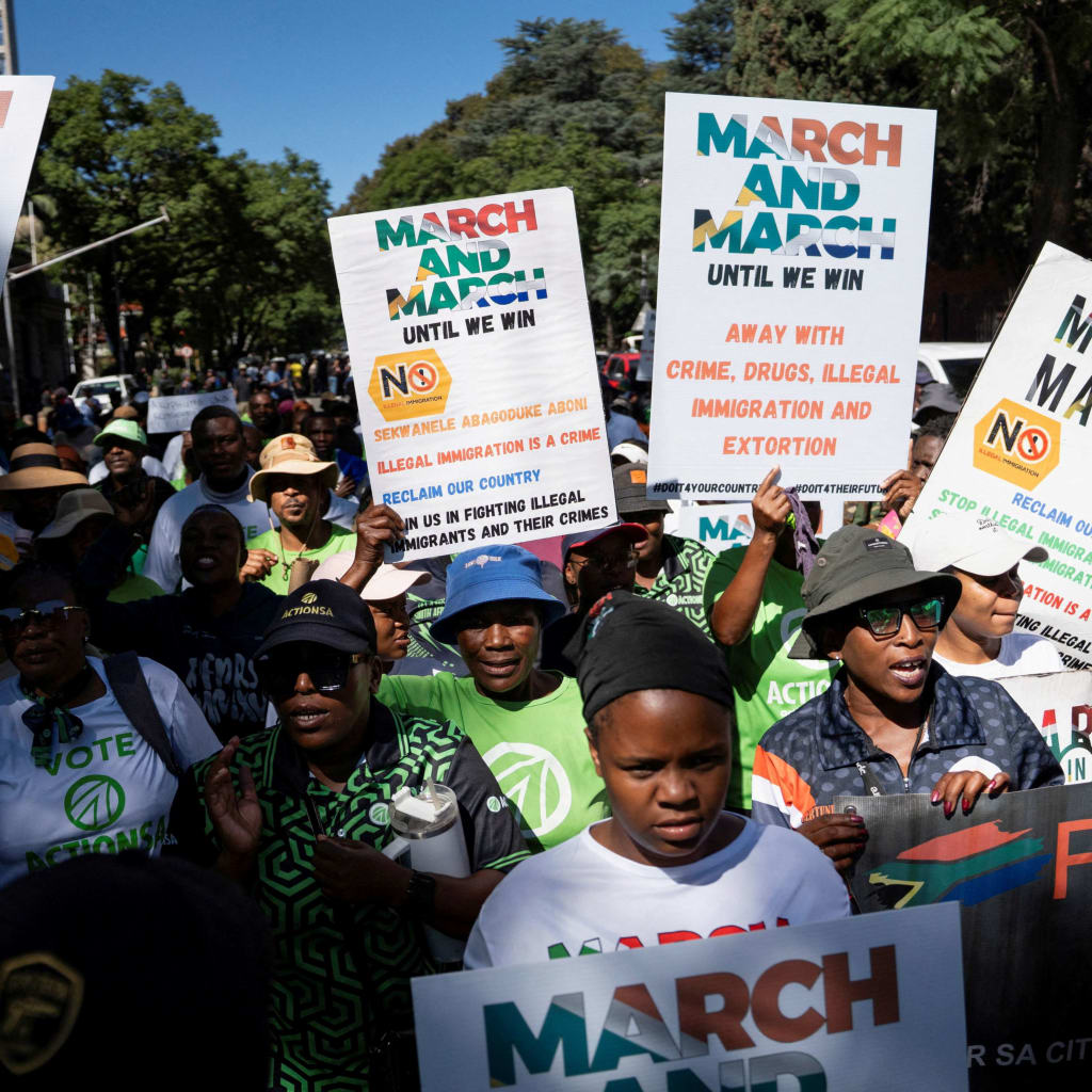 <p>Members of civil society groups and human rights organizations hold placards as they take part in a march calling for stronger government action against illegal immigration in Pretoria, South Africa, on April 28, 2026.</p>
