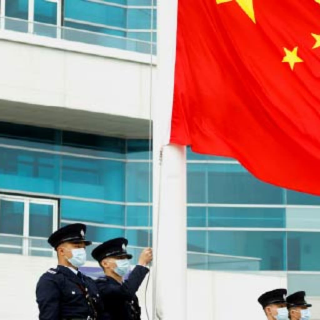 Chinese policemen raise a Chinese flag.