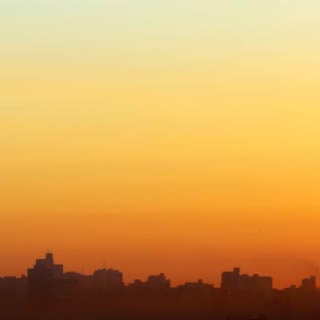A skyline view of the city of Johannesburg. A tall tower, the Hillbrow Tower, stands in the center.