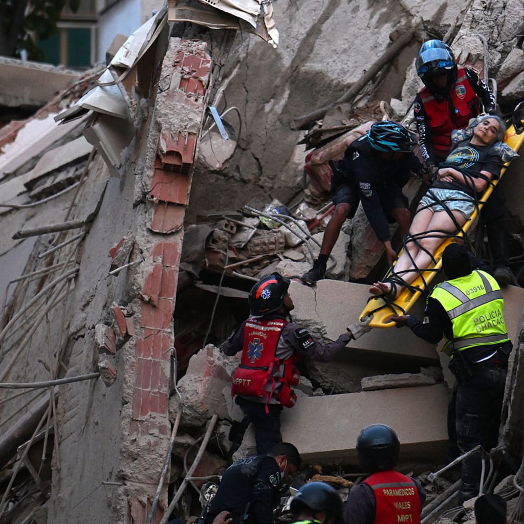 Rescue workers carry a person on a stretcher out of a collapsed building following an earthquake in Caracas on June 24, 2026.
