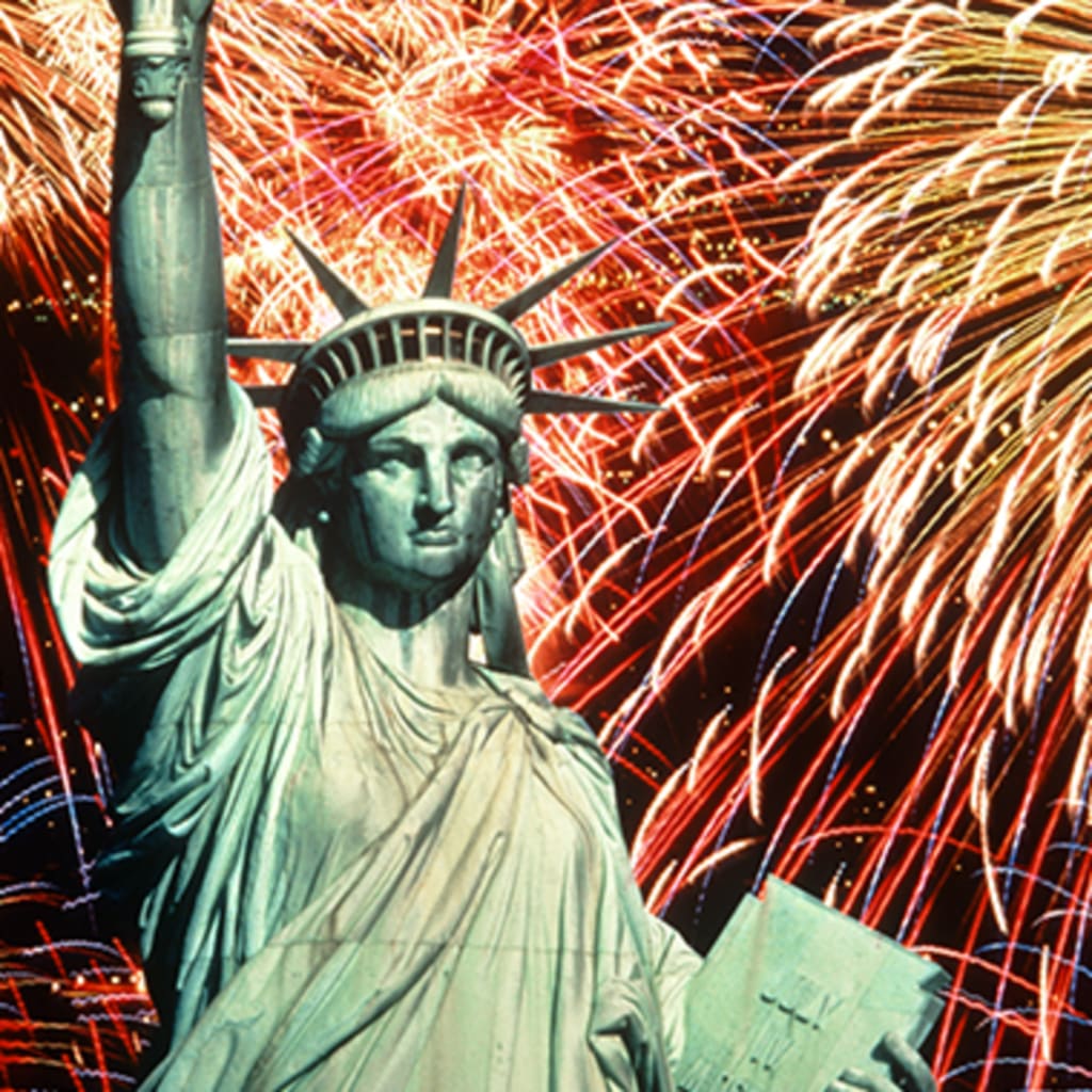 Fireworks explode behind the Statue of Liberty