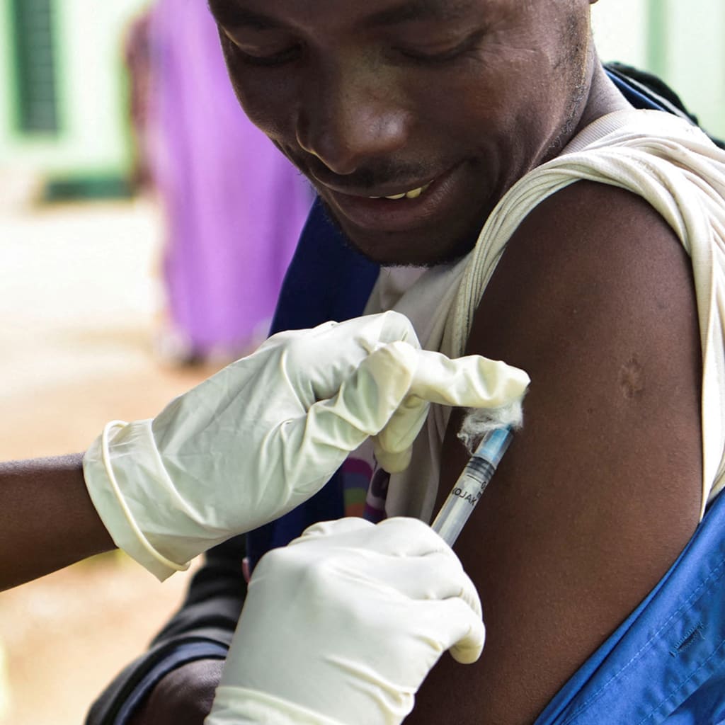A Nigerian health official administers an mpox vaccine to a man at Mando Primary Health Care Center.