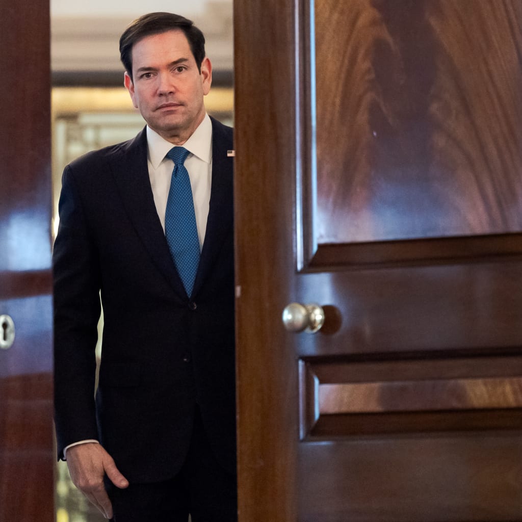 Secretary Of State Rubio is framed by an open wooden door at the State Dept.