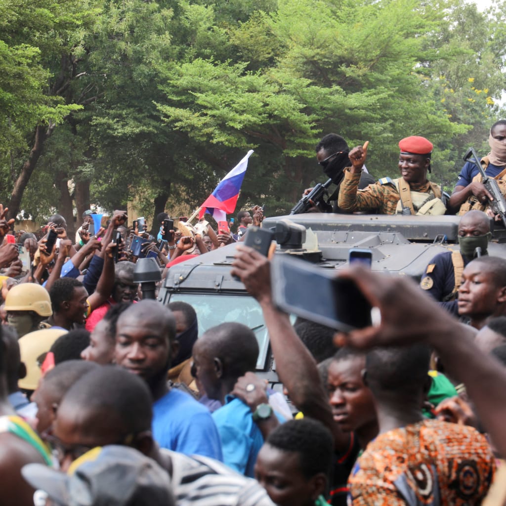 Burkina Faso’s self-declared leader Ibrahim Traore is surrounded by supporters holding Russian flags in Ouagadougou, Burkina Faso, on October 2, 2022.