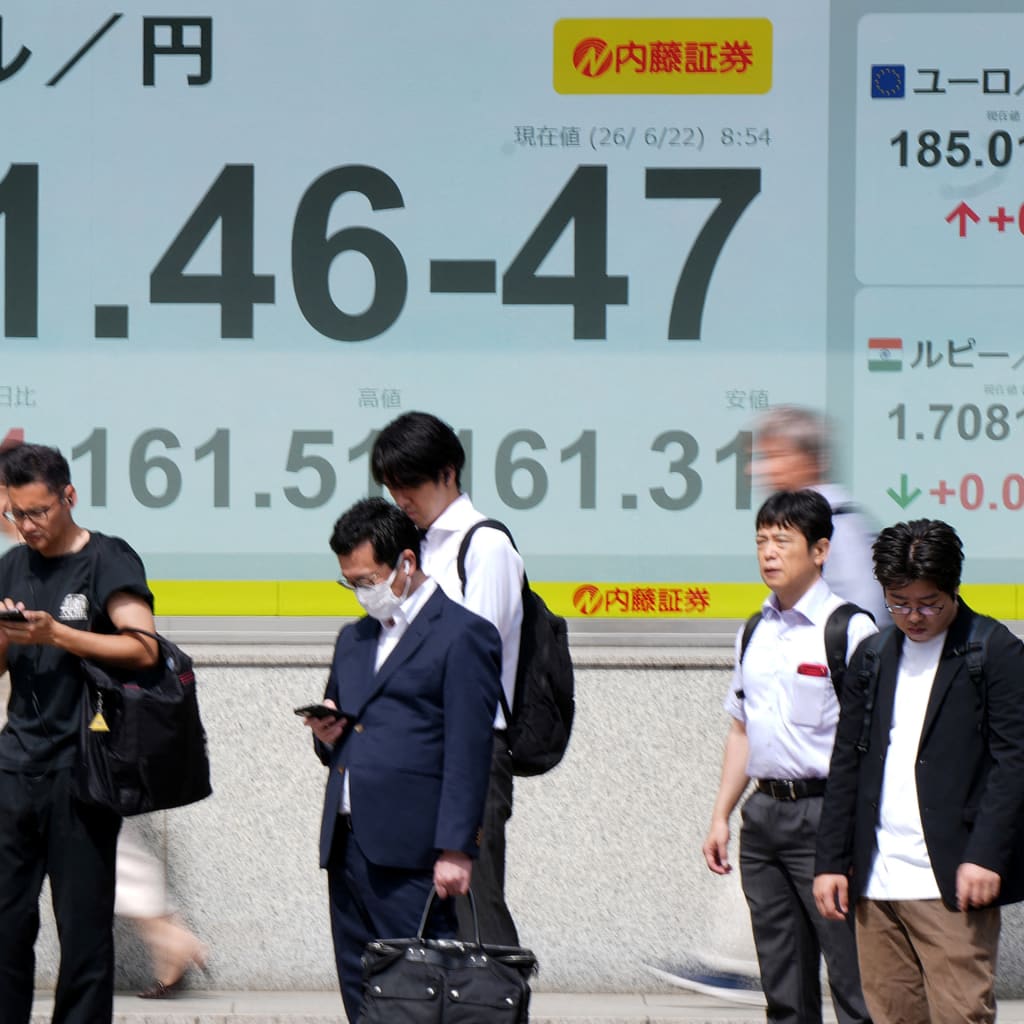 Pedestrians stand in front of electronic boards displaying the foreign exchange rate of the Japanese yen against the US dollar (L) and other currencies (R), along a street in Tokyo on June 22, 2026.