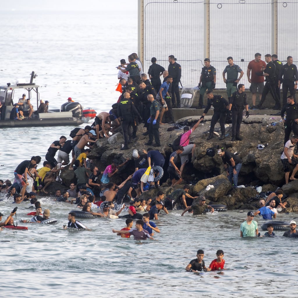 <p>Dozens of migrants celebrate having crossed the border between Ceuta and Morocco, on July 31, 2026.</p>

