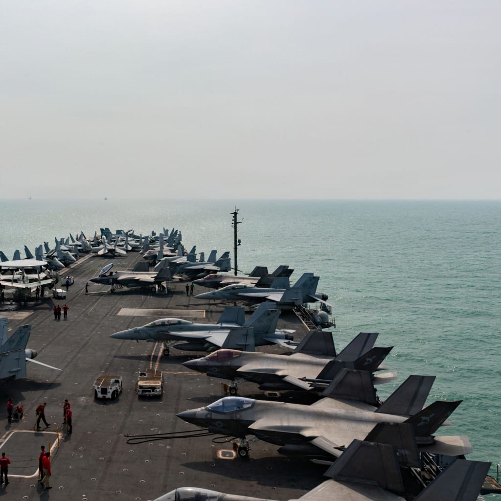Several fighter jets sit on top of the deck of the The U.S. Navy Nimitz-class aircraft carrier USS George Washington as it transits the Strait of Malacca.