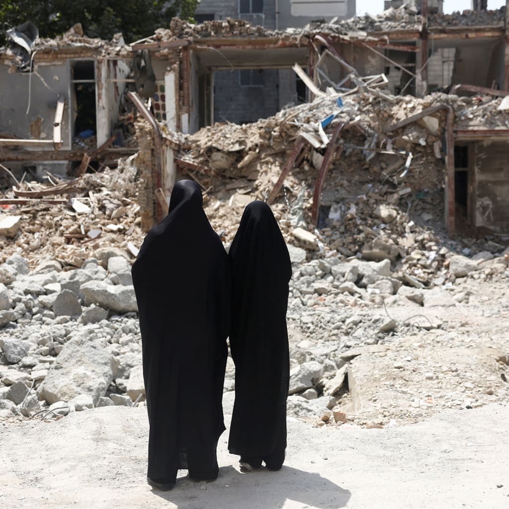 Iranian women look at a building, which was damaged in a U.S. and Israeli strike in March, in Tehran, Iran, August 22, 2026.