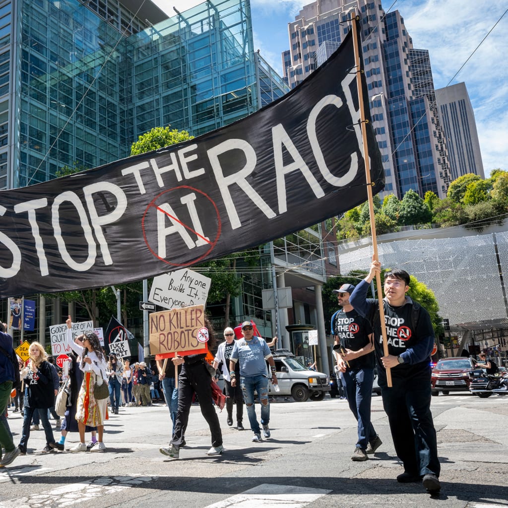 Demonstrators carry a large banner with the words 'Stop the AI race' as they participate in the Stop the AI Race protest march in San Francisco, California, on July 11, 2026. The march included stops outside the offices of OpenAI, Anthropic, and Google DeepMind.
