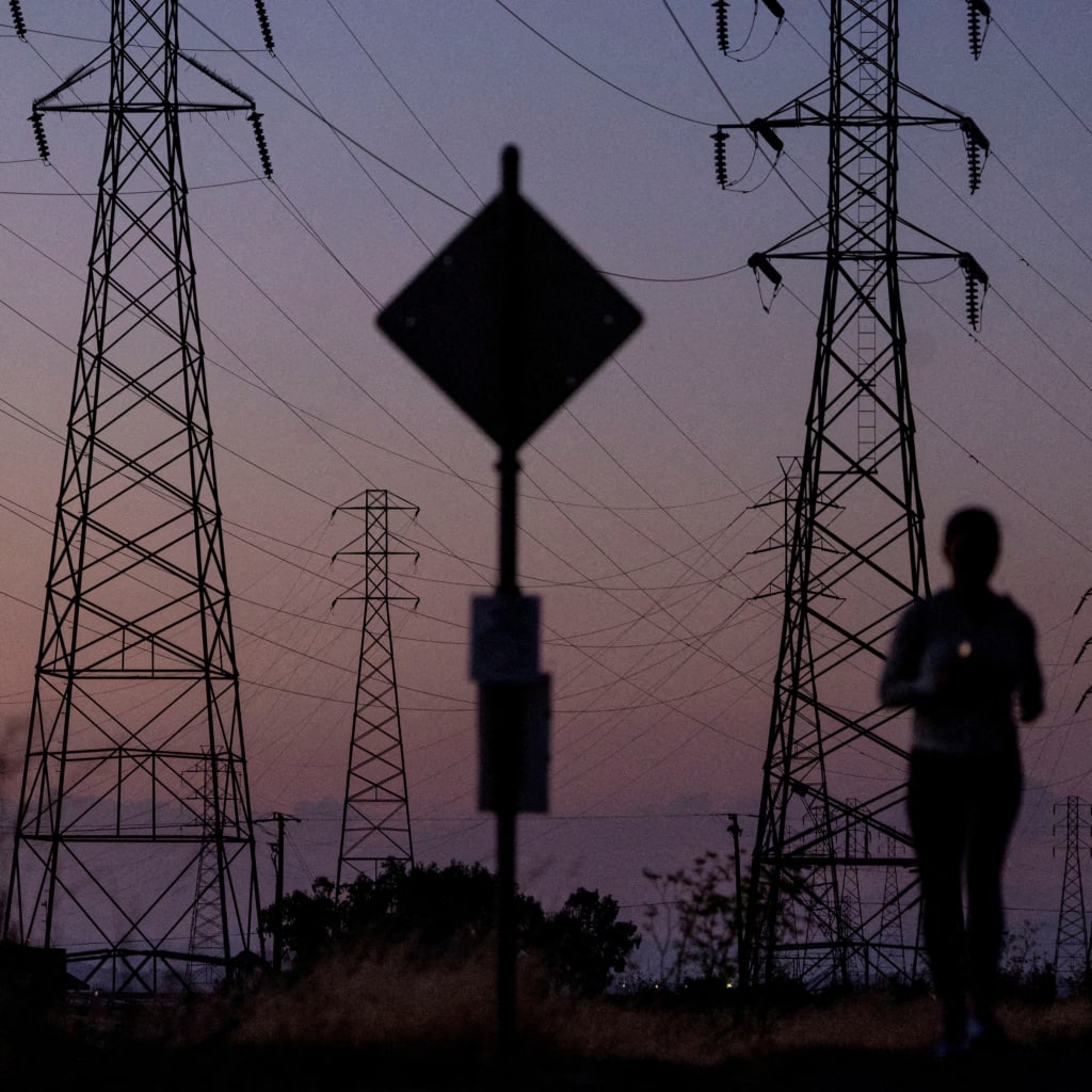 A woman jogs by power lines in California in August 2022.