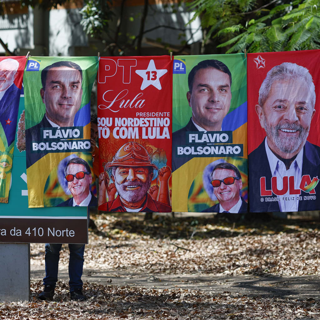<p>Towels and caps for sale in a residential area of Brasília depict Brazilian presidential candidates Luiz Inácio Lula da Silva and Flávio Bolsonaro, on September 11, 2026.</p>