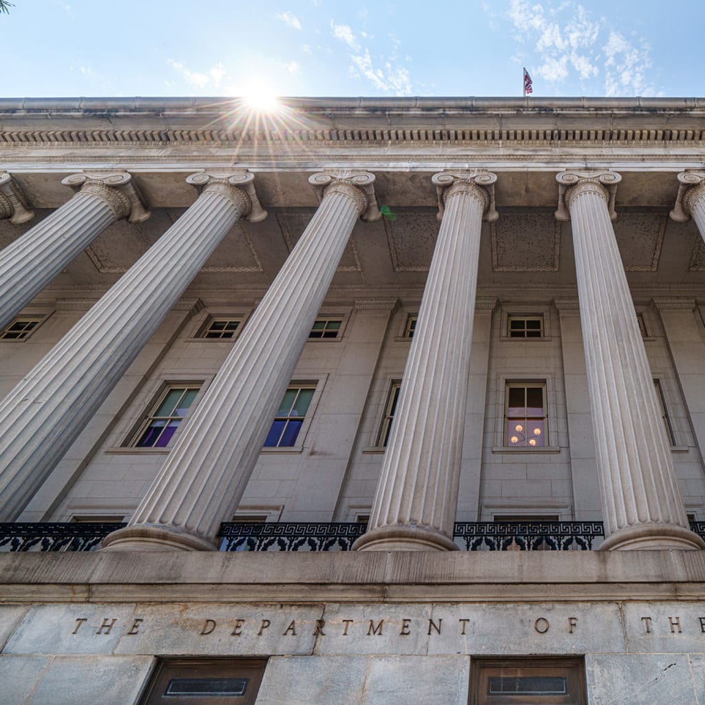 The sun flares over the top of the side entrance to the U.S. Treasury Department Building on August 18, 2024, in Washington, DC.