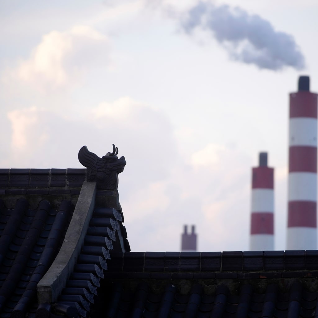 Chimneys of a coal-fired power plant are seen behind a gate in Shanghai, China October 21, 2021. REUTERS/Aly Song