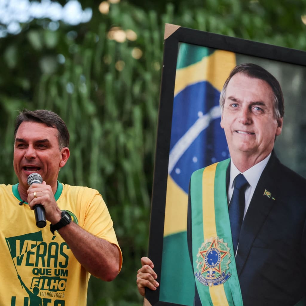 Brazilian presidential candidate Flavio Bolsonaro of the Liberal Party (PL) speaks next to a portrait of his father, Brazil's former President Jair Bolsonaro, during a campaign rally in Goiania, Brazil, September 27, 2026.
