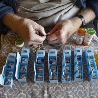 Disabled person with Multiple Sclerosis hand sorting prescription pills