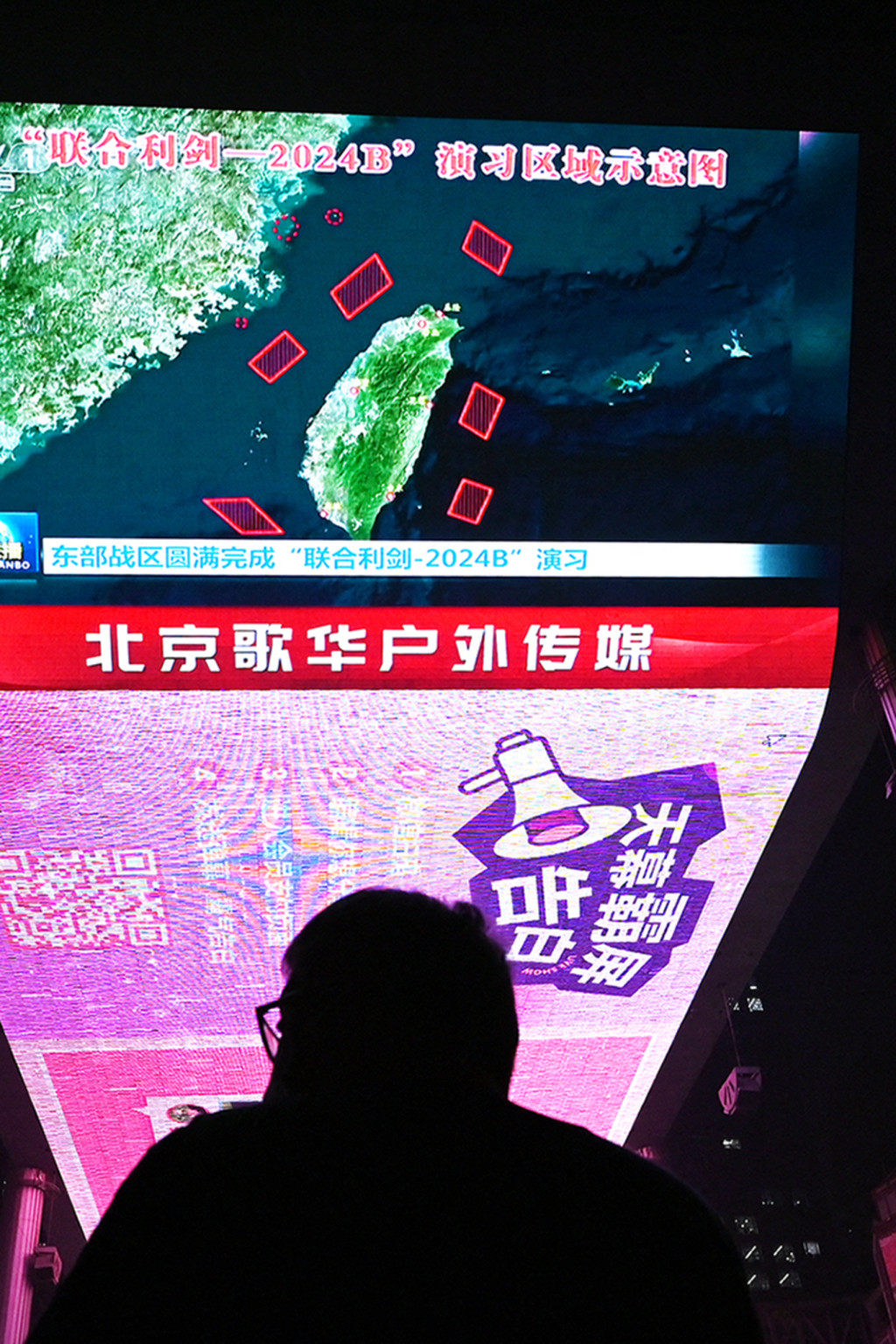 <p>A man in Beijing watches a news program about Chinese military drills surrounding Taiwan.</p>
