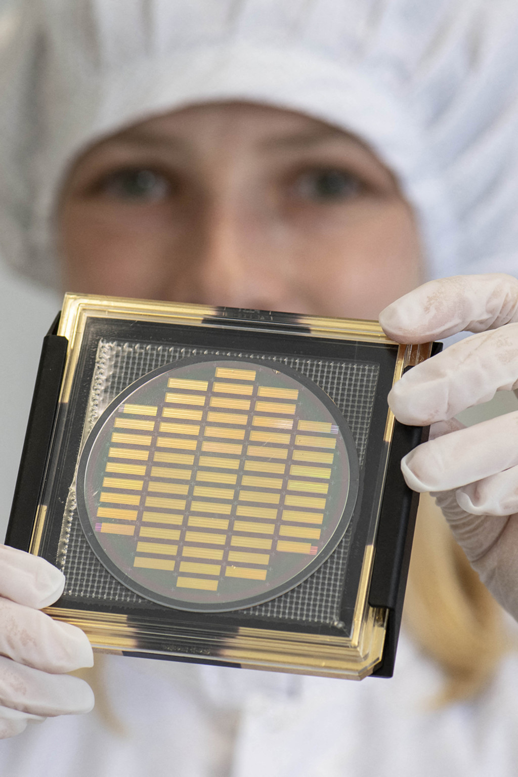 <p>An engineer shows a wafer with photonic chips for quantum computing at the company Q.ANT.</p>