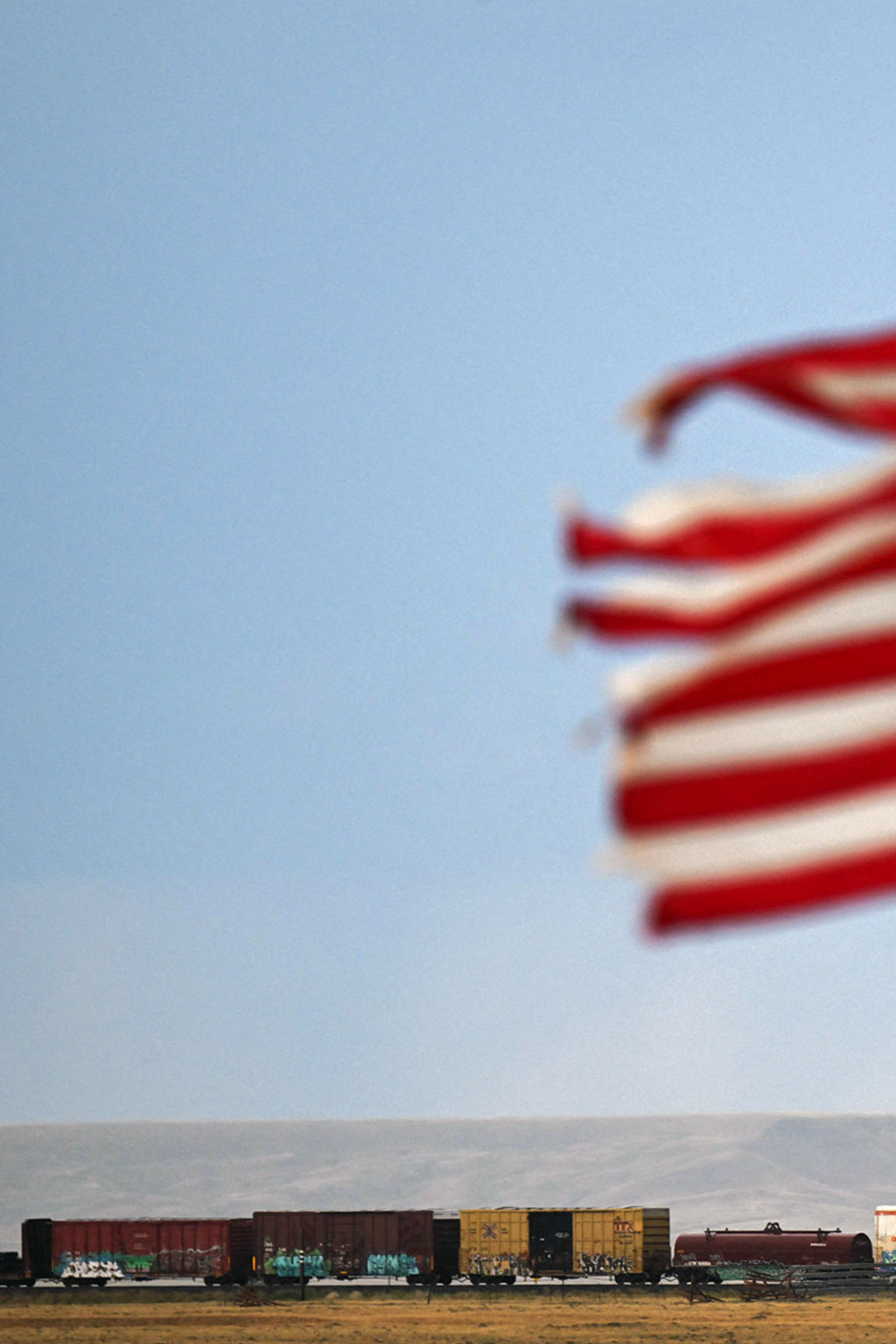 <p>A U.S. flag waves above a freight train in Bosler, Wyoming.</p>

