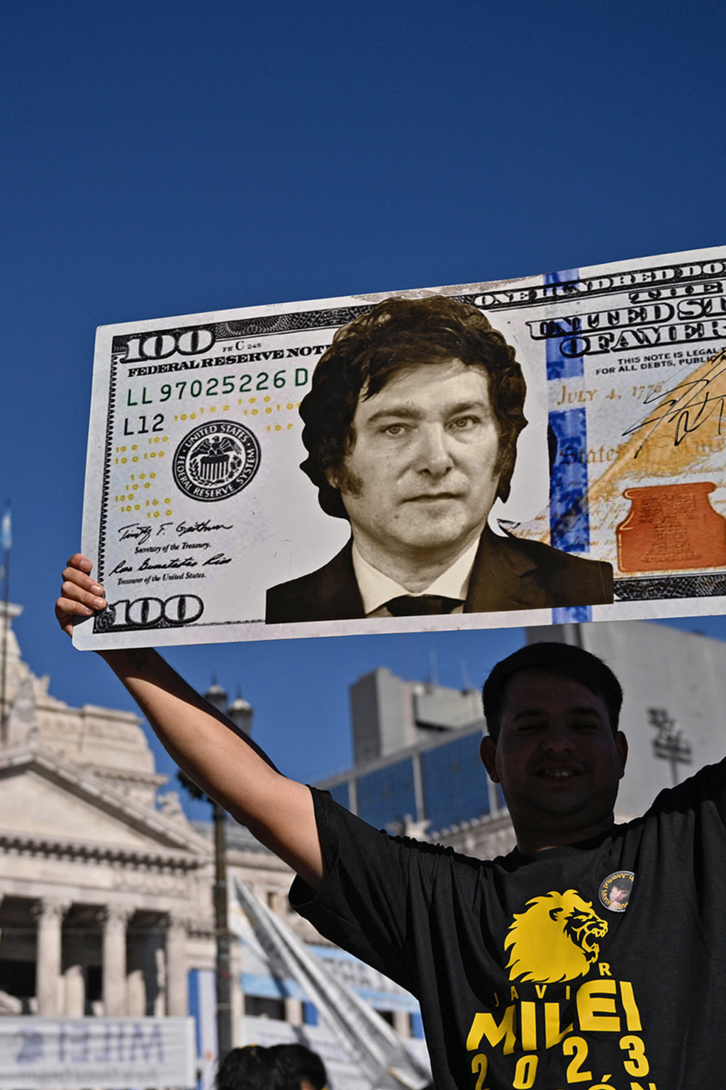 <p>A supporter holds up a $100 bill sign of then President-Elect Javier Milei in December 2023.</p>
