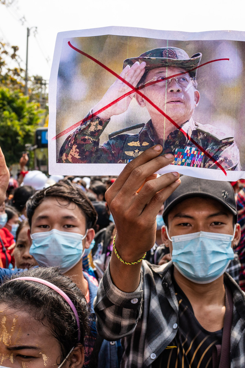 <p>A protester holds an image of Senior General Min Aung Hlaing during an anti-coup march in February 2021.</p>
