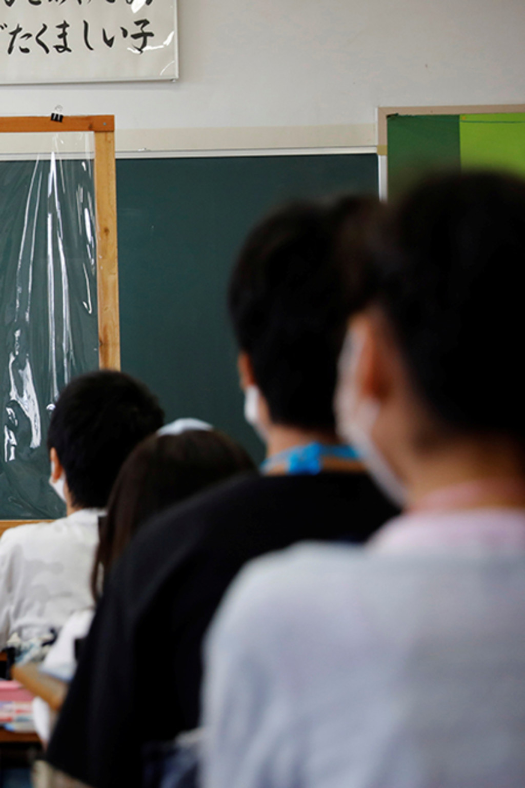 <p>A student gives an English presentation behind a plastic sheet at a Funabashi elementary school.</p>
