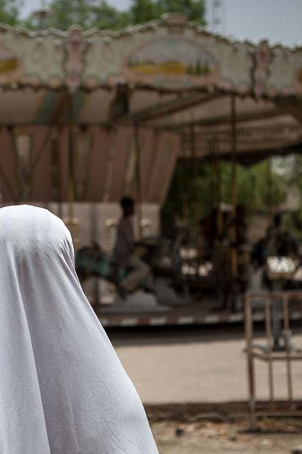 <p>A girl watches a merry-go-round at an abandoned amusement park in Maiduguri, Nigeria.</p>
