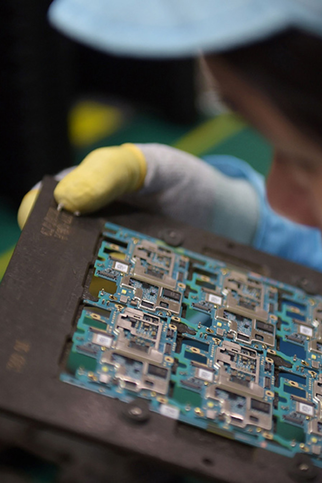 <p>A worker handles smartphone chip components at a factory in Dongguan, China.</p>
