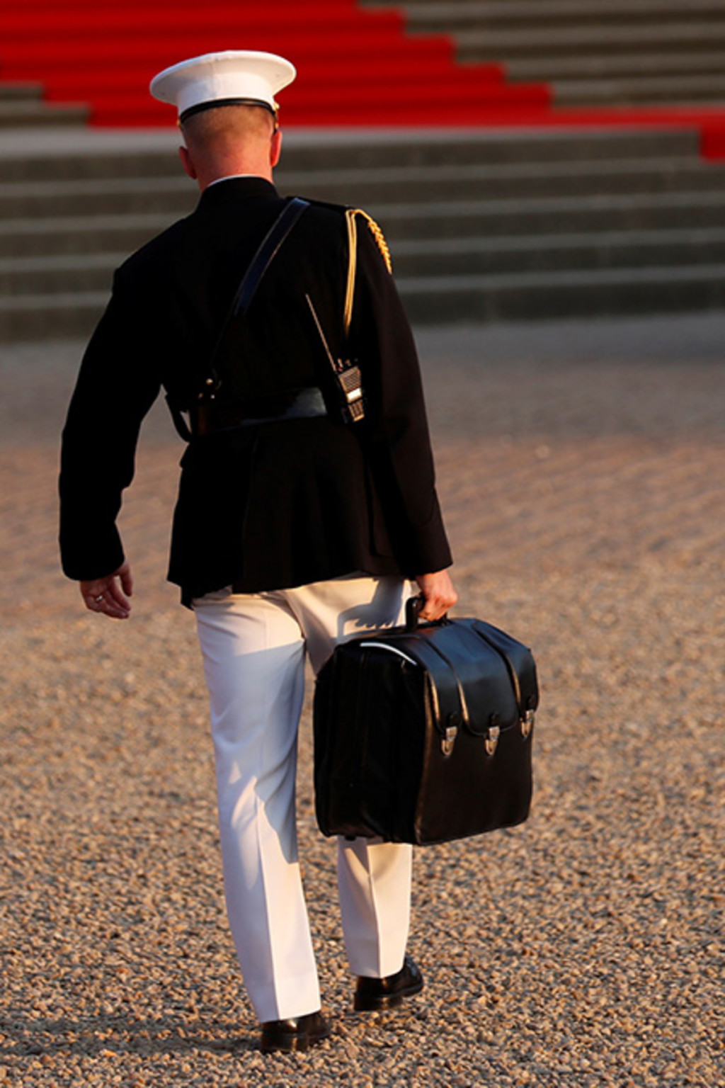 <p>A military aide carries the “football” containing launch codes for U.S. nuclear weapons.</p>
