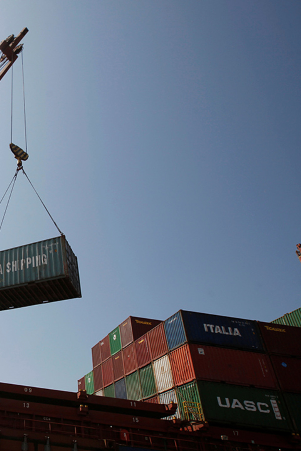 <p>Workers use a crane to unload shipping containers at a port in Yemen.</p>

