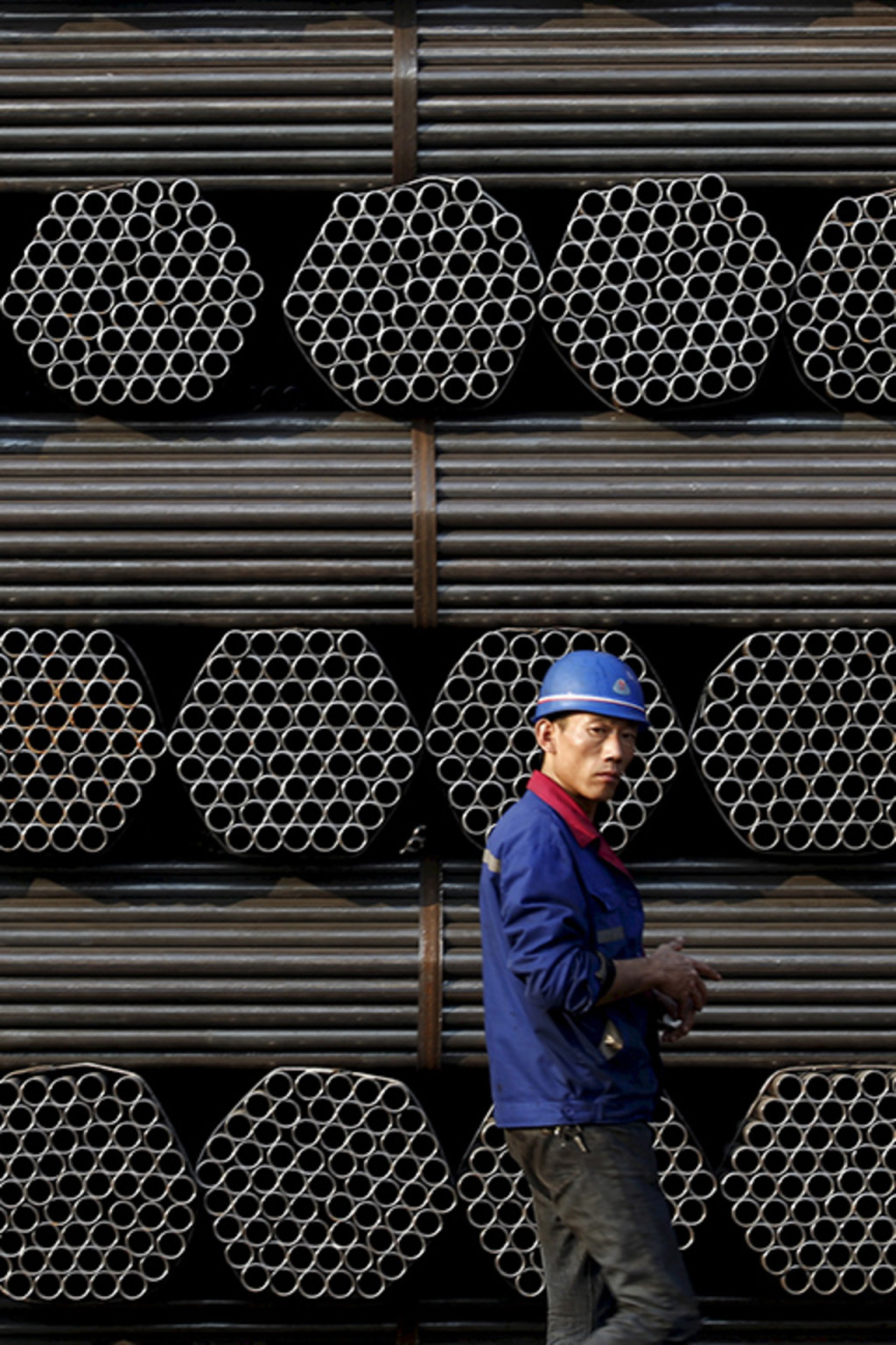 <p>A worker stands in front of steel piping at a plant in China’s Hebei Province.</p>
