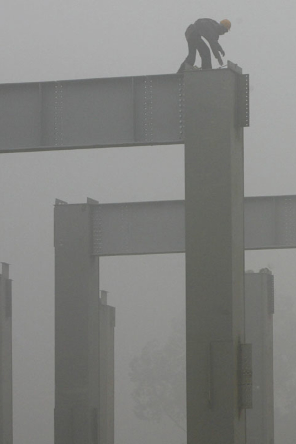 <p>A Delhi Metro Rail Corporation worker works amidst thick fog at a construction site in New Delhi.</p>