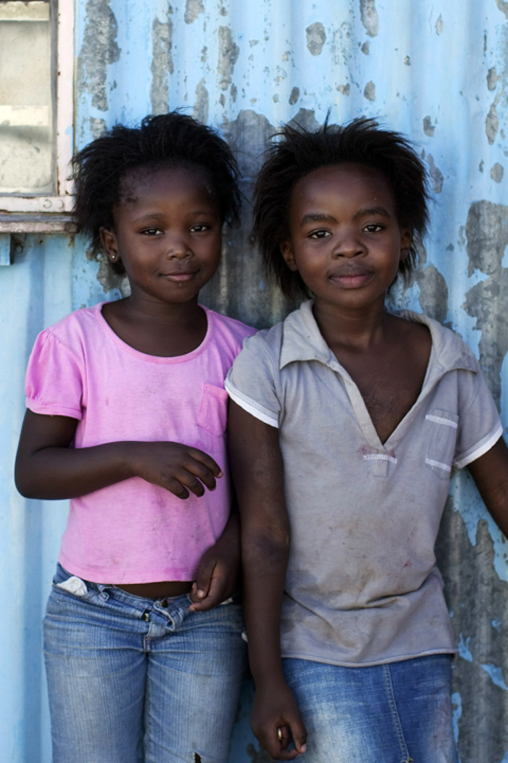 <p>Girls stand outside shacks made from metal in Cape Town’s Khayelitsha township.</p>

