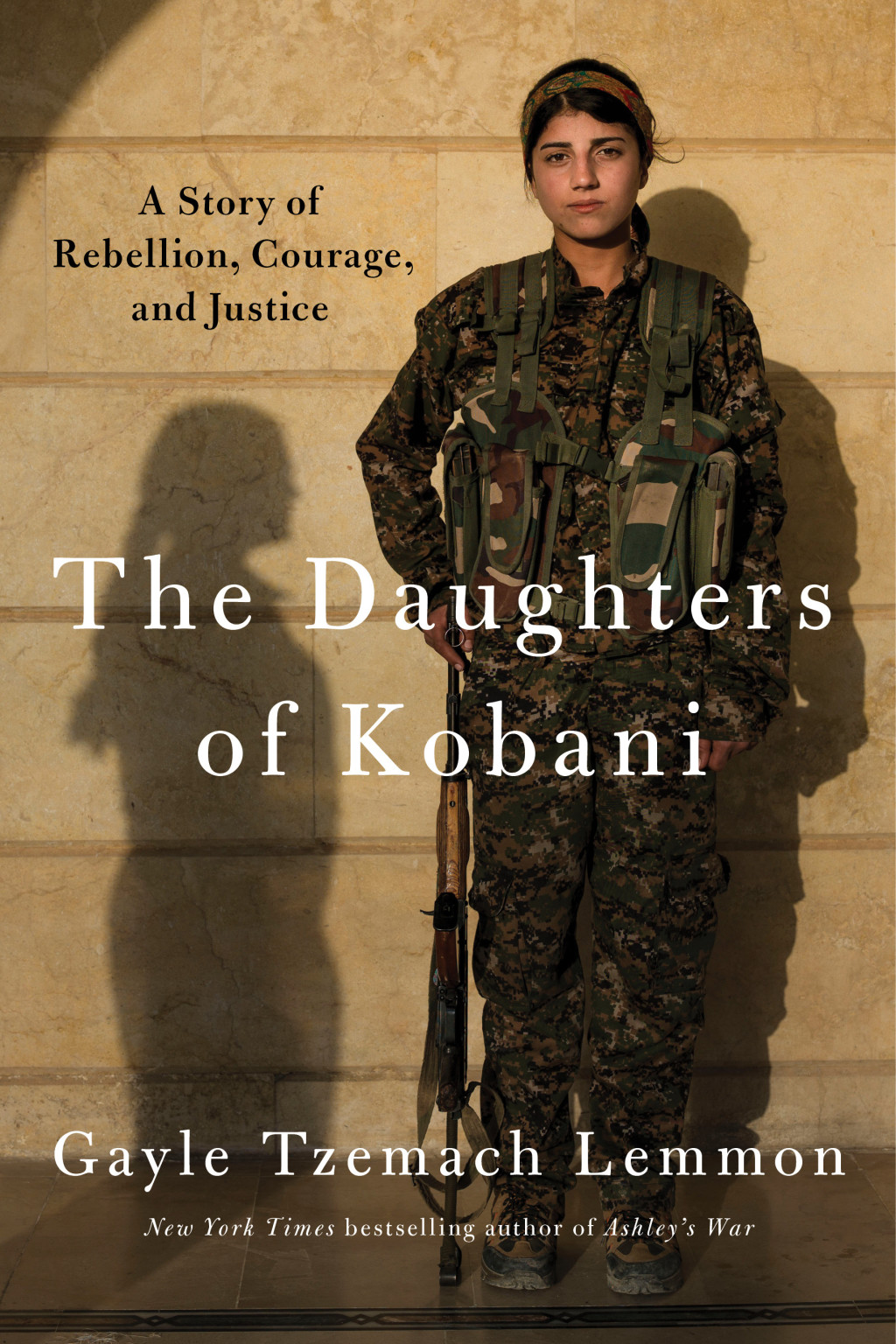 A woman in combat fatigues stands with a gun next to the shadow of another woman